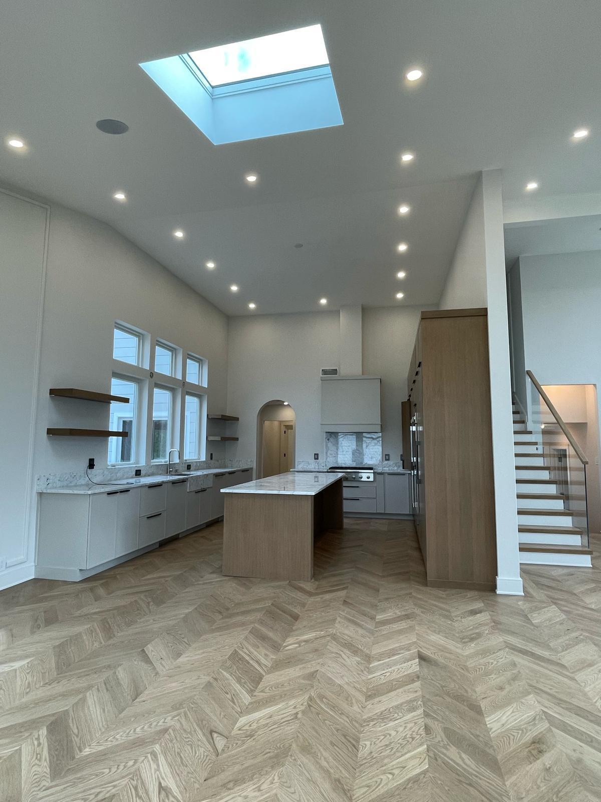Modern kitchen with vaulted ceilings & herringbone floors