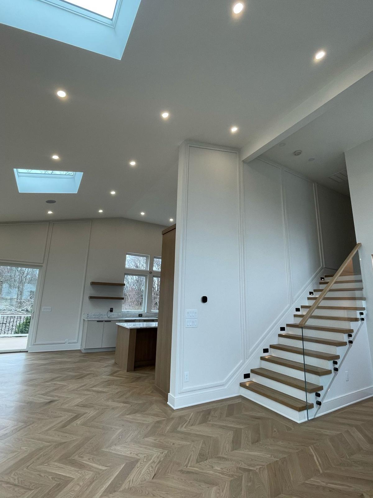 Floating oak staircase with paneled accent wall